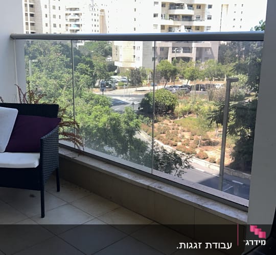 מרפסת עם מעקה זכוכית ונוף עירוני